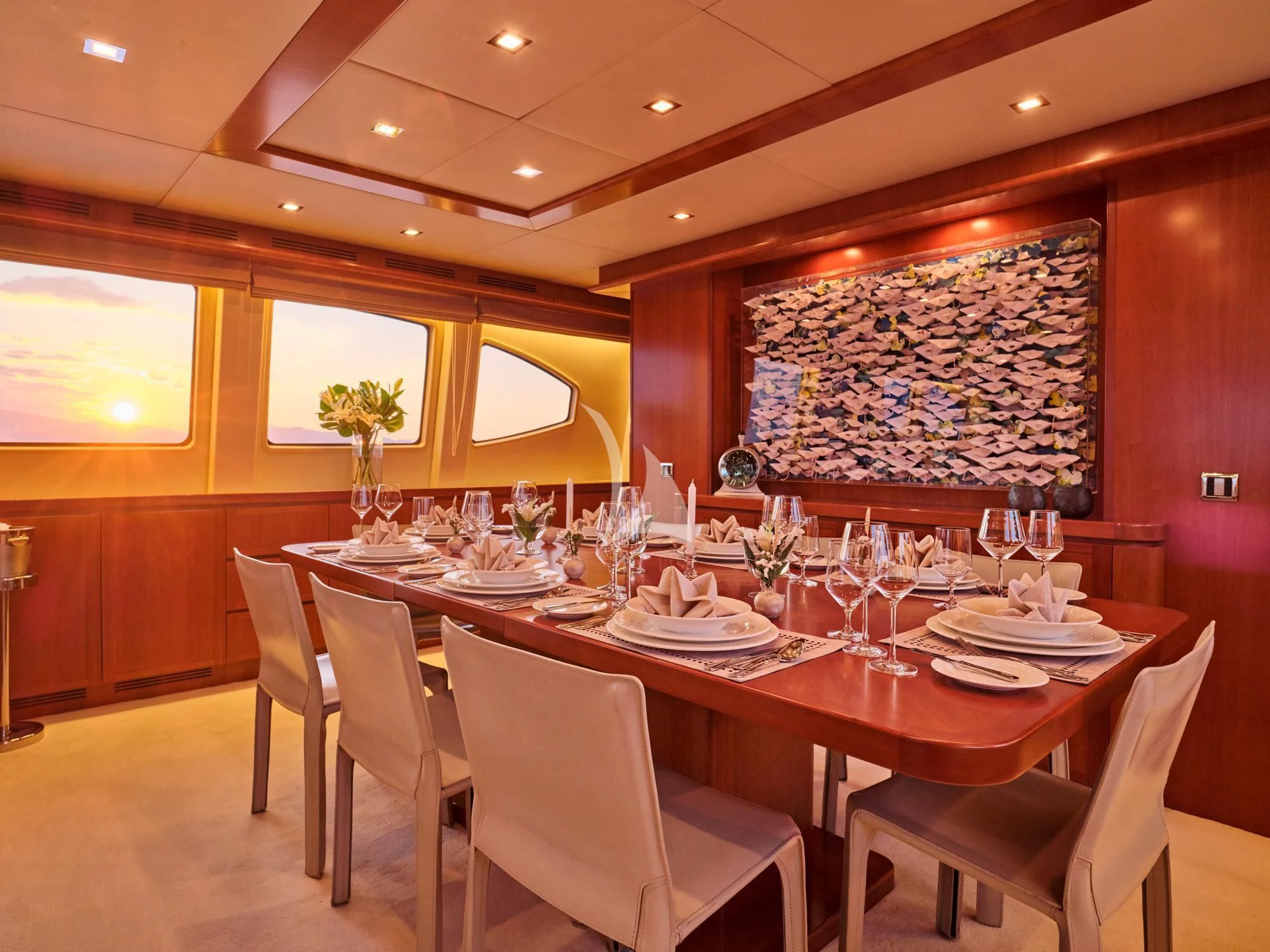 a dining room table with white chairs aboard HELIOS Yacht for Charter