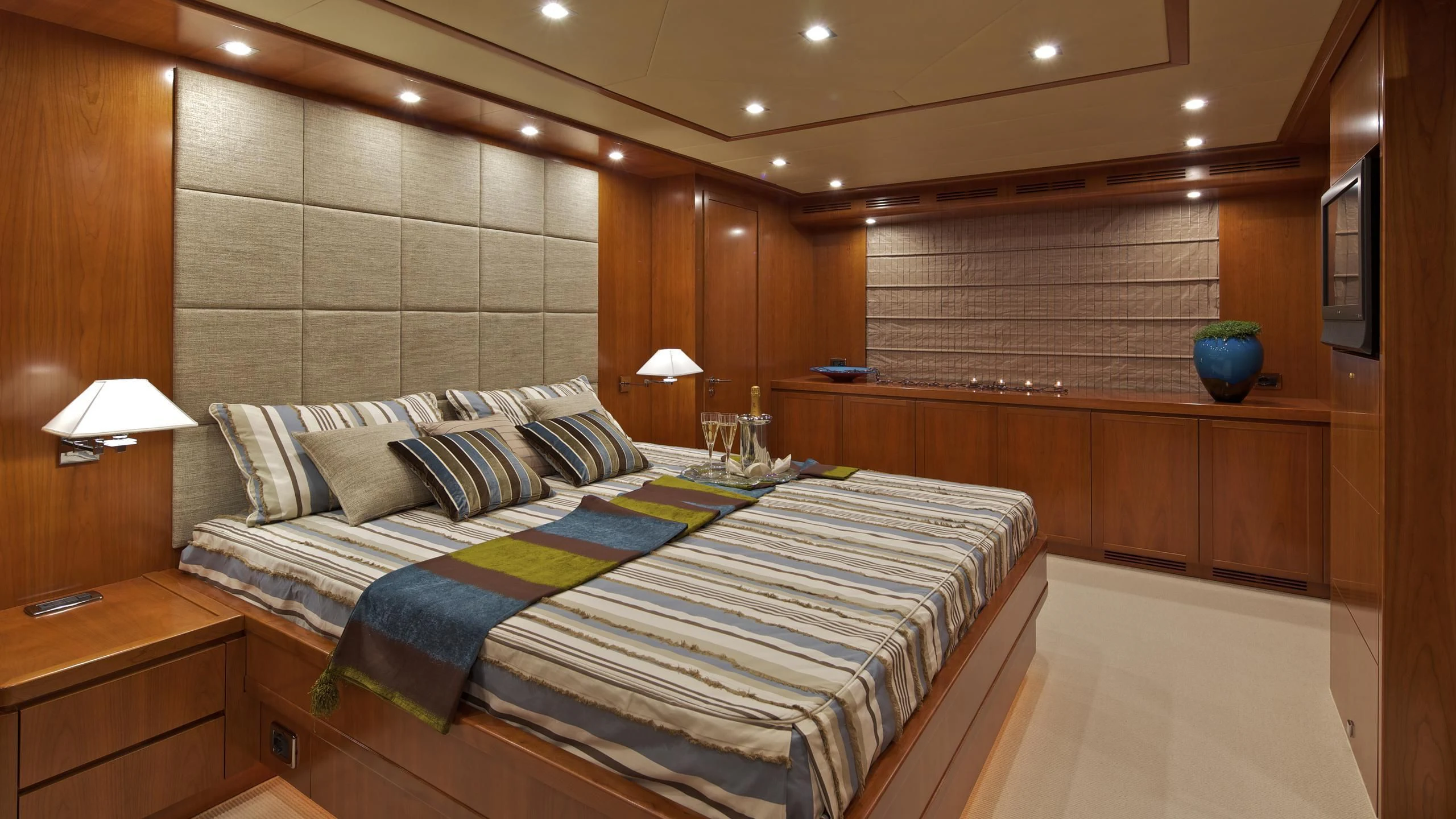 a room with a bed and a table aboard HELIOS Yacht for Charter