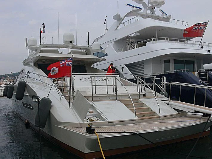 a boat docked with a flag aboard ESCAPE Yacht for Sale