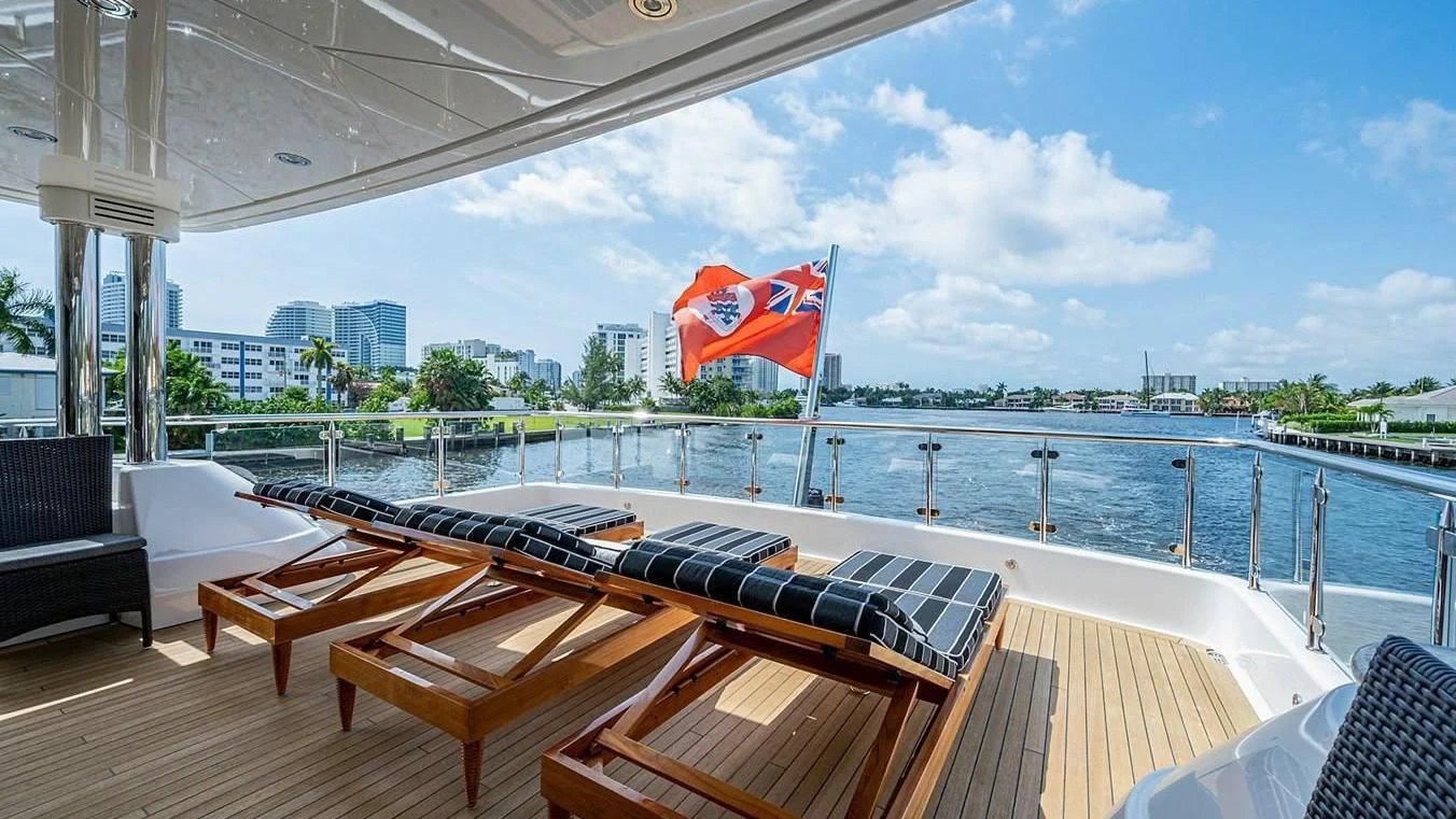 a deck with a large body of water and a large city in the background aboard NIGHT HOWL Yacht for Sale