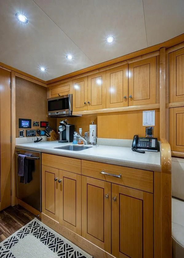 a kitchen with wooden cabinets aboard NIGHT HOWL Yacht for Sale