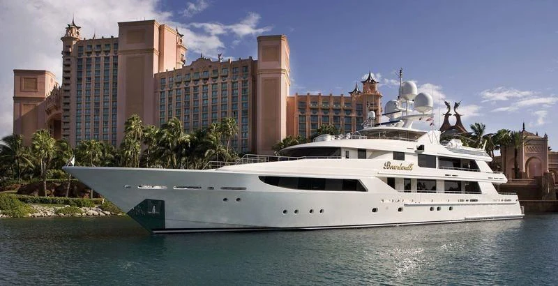 a white yacht in front of a large building aboard NIGHT HOWL Yacht for Sale