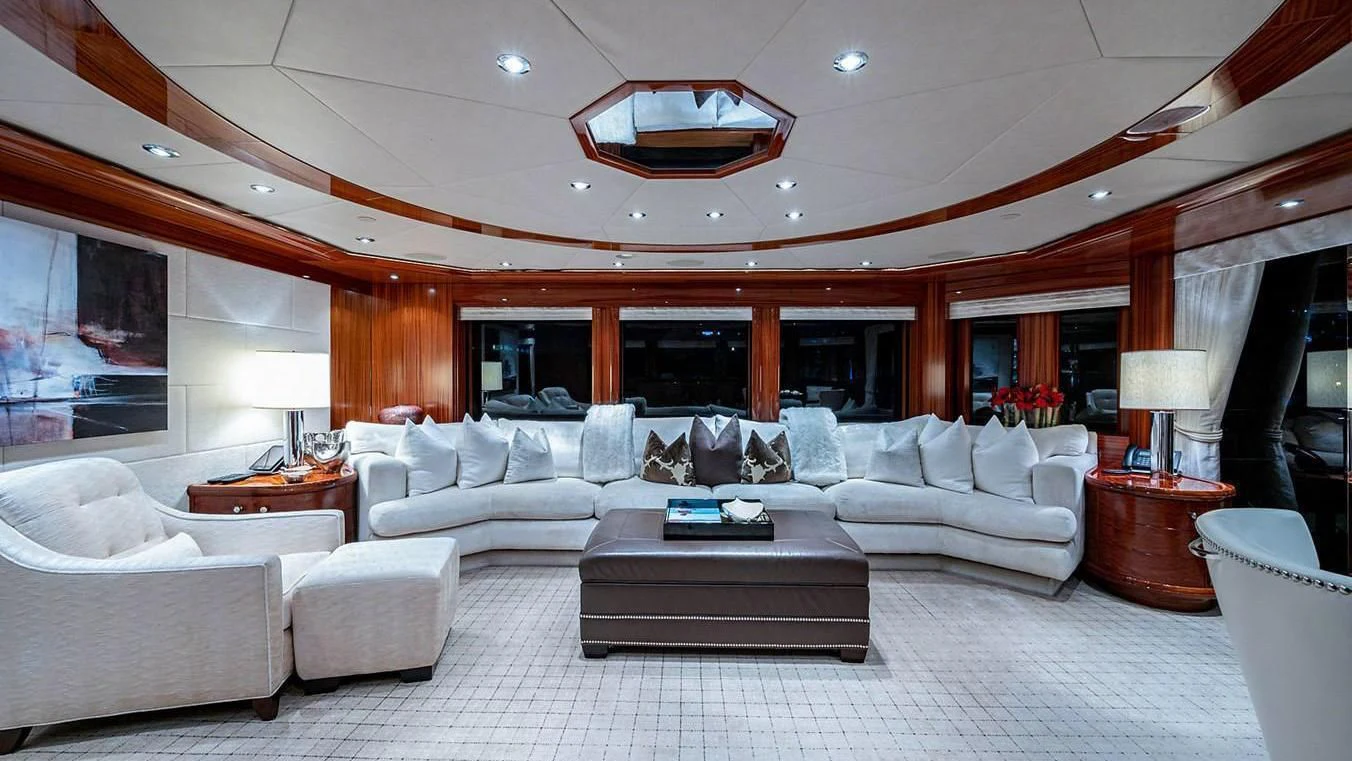a large living room with a large white sofa and a large window aboard NIGHT HOWL Yacht for Sale