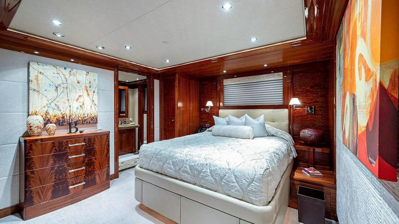 a bedroom with a bed and a dresser aboard NIGHT HOWL Yacht for Sale