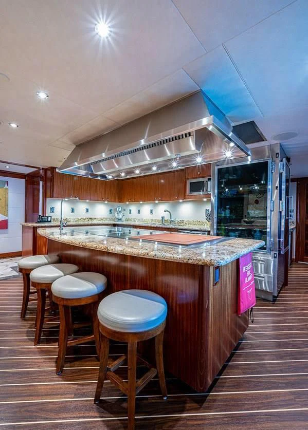 a kitchen with a bar and stools aboard NIGHT HOWL Yacht for Sale