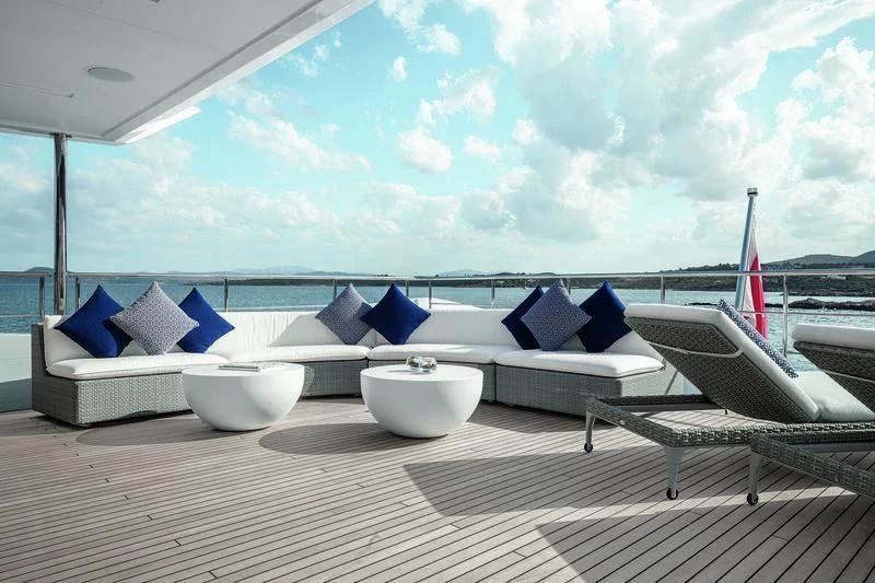a large white lounge chair on a deck overlooking a body of water aboard WILLOW Yacht for Charter