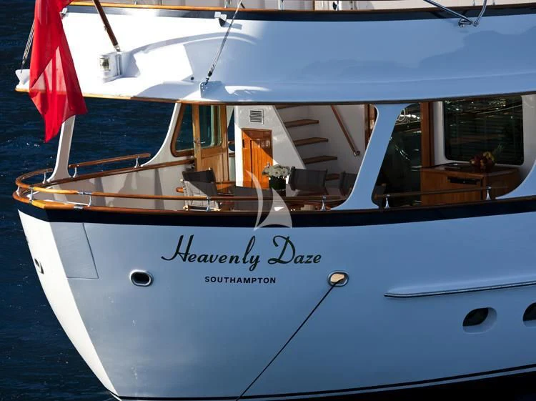 a white boat with a red and white flag on the front aboard HEAVENLY DAZE Yacht for Sale