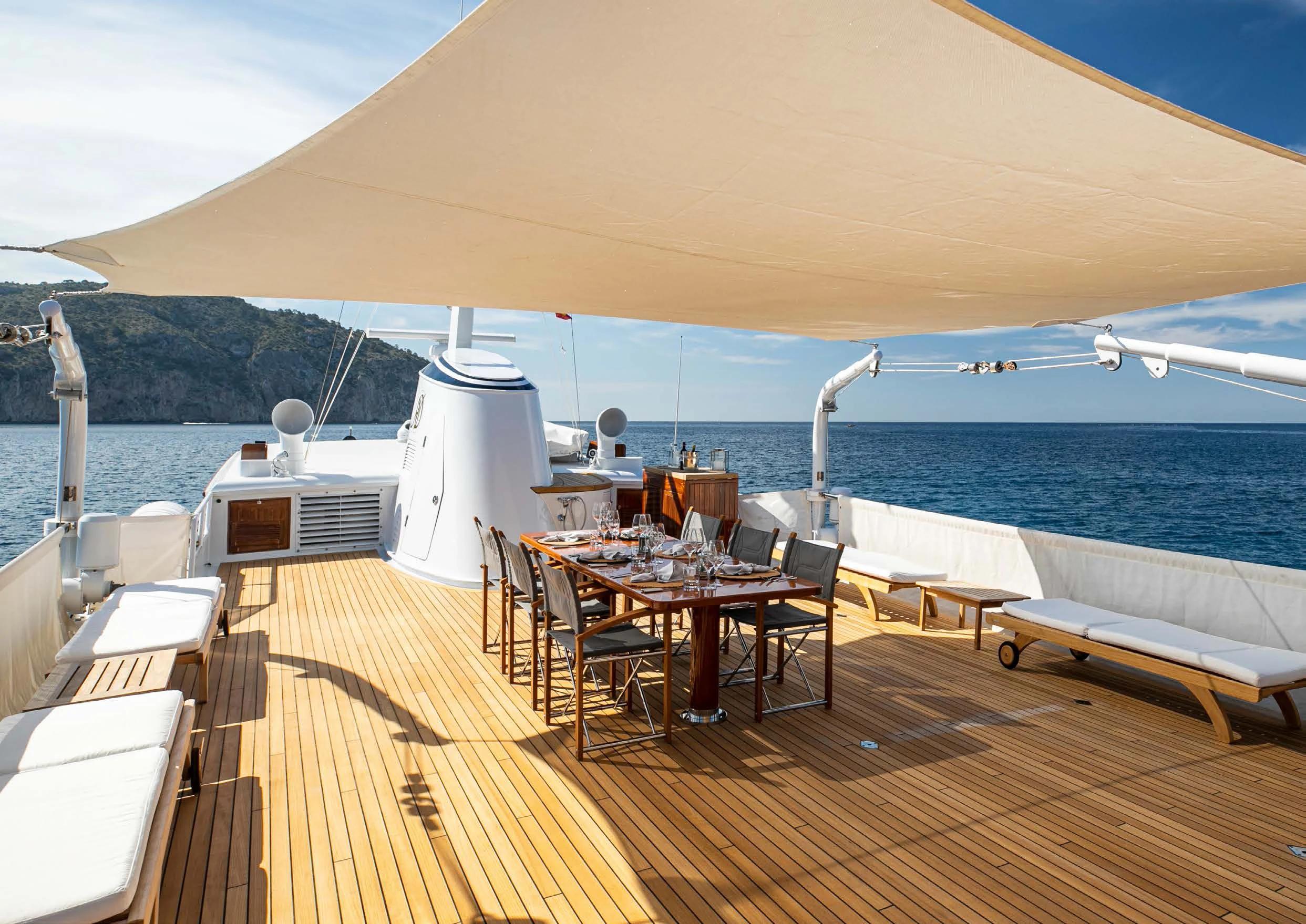 a deck with tables and chairs on it aboard HEAVENLY DAZE Yacht for Sale