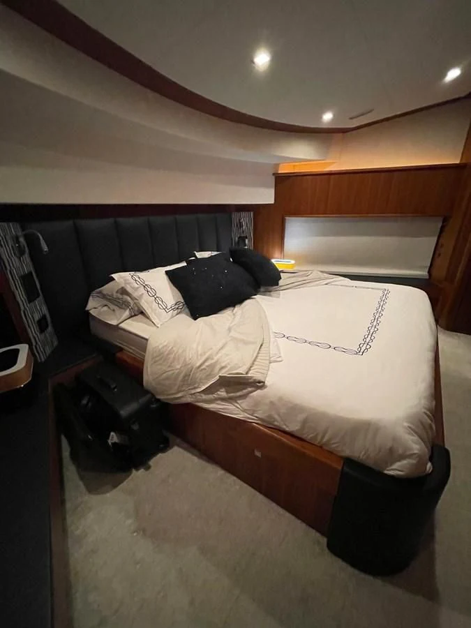 a bed with a white sheet and black pillows aboard SOLARIS Yacht for Sale