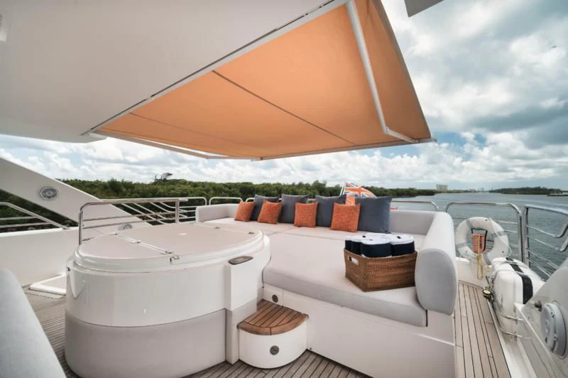 a white boat with a large orange umbrella on the deck aboard SOLARIS Yacht for Sale
