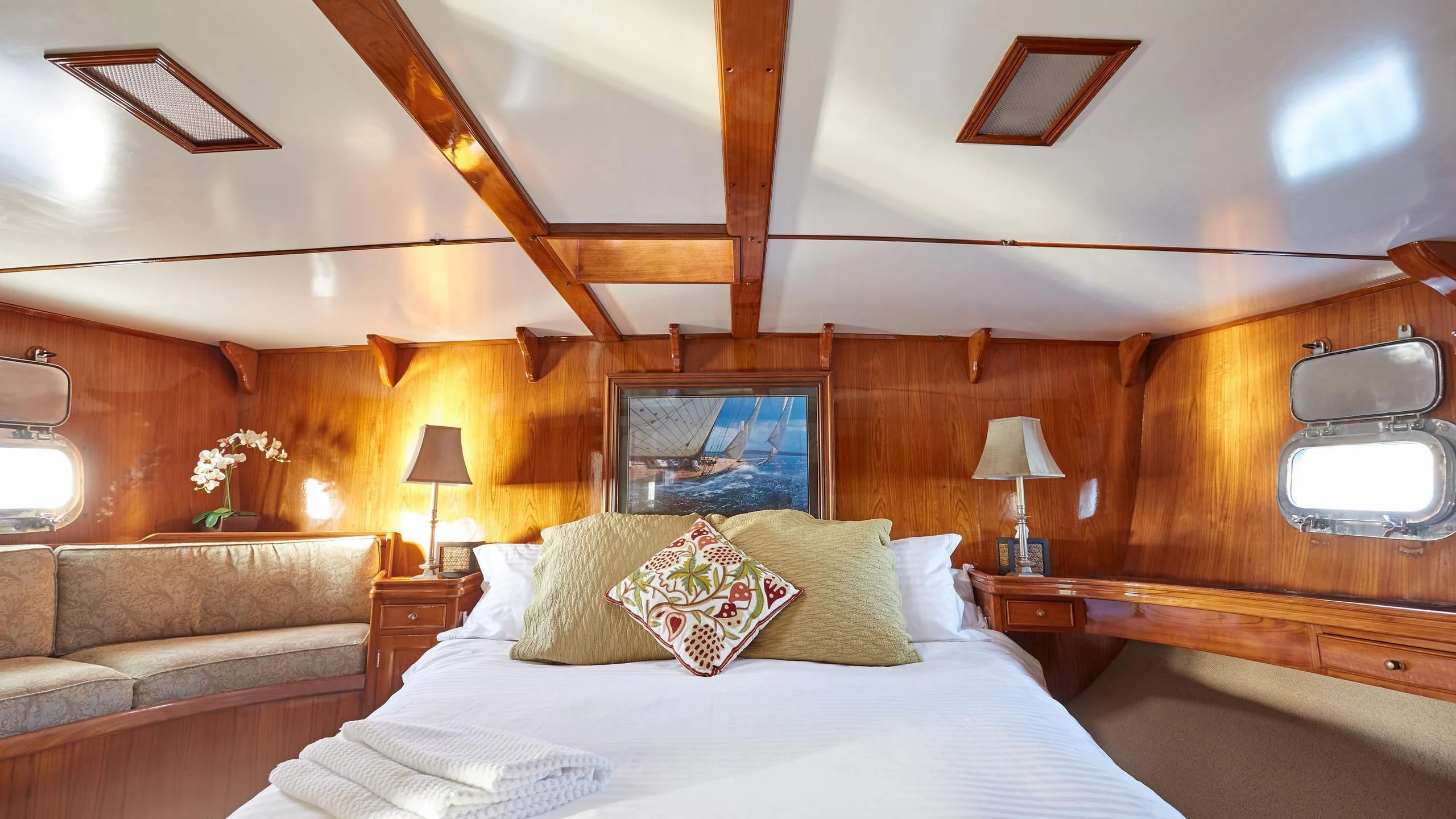 a bed with pillows and a couch aboard SLOW DANCE Yacht for Sale