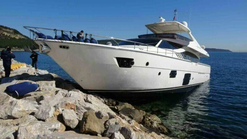 a white yacht on a rocky shore aboard GEMINI Yacht for Sale