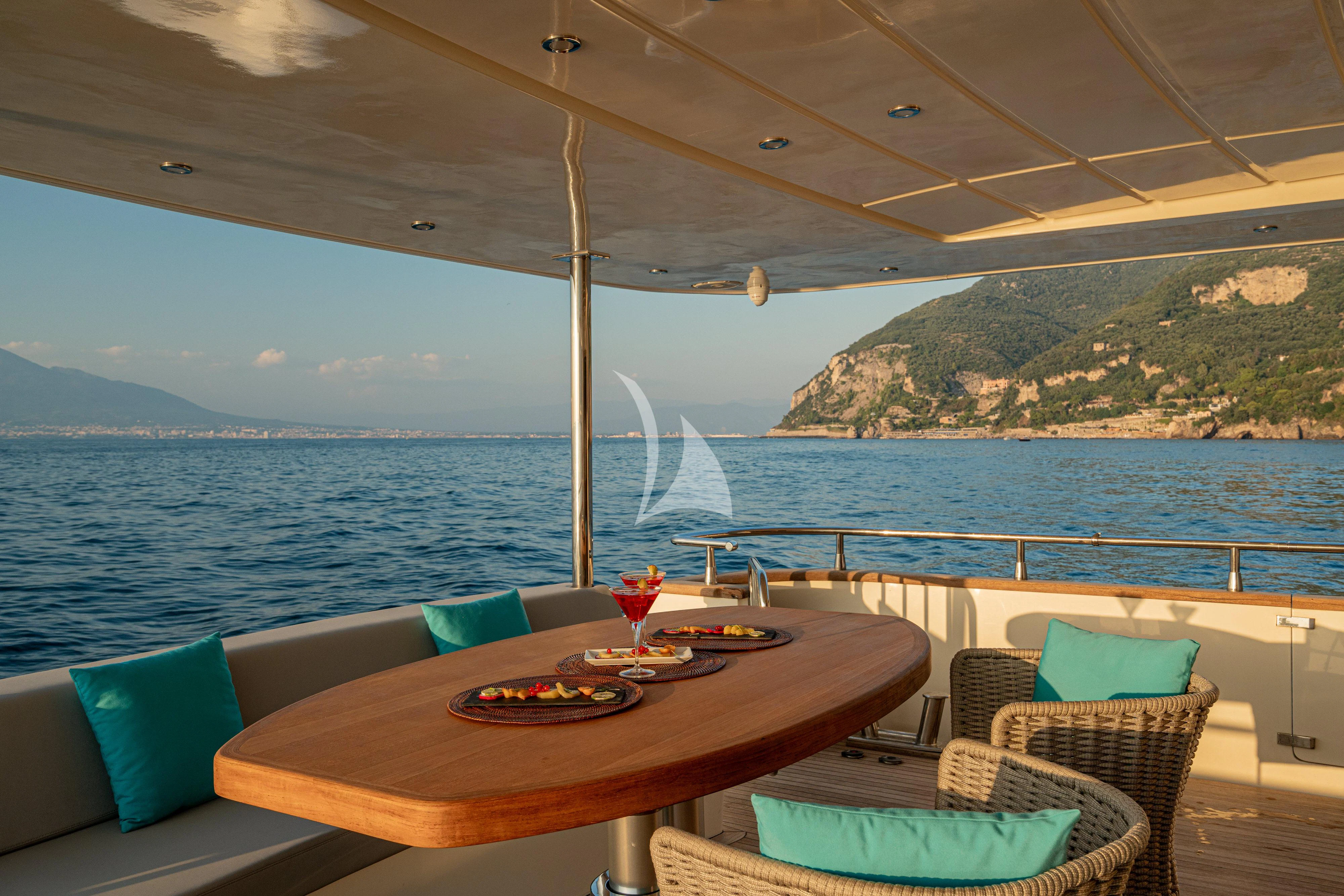 a table on a deck overlooking the ocean aboard MINOU Yacht for Sale