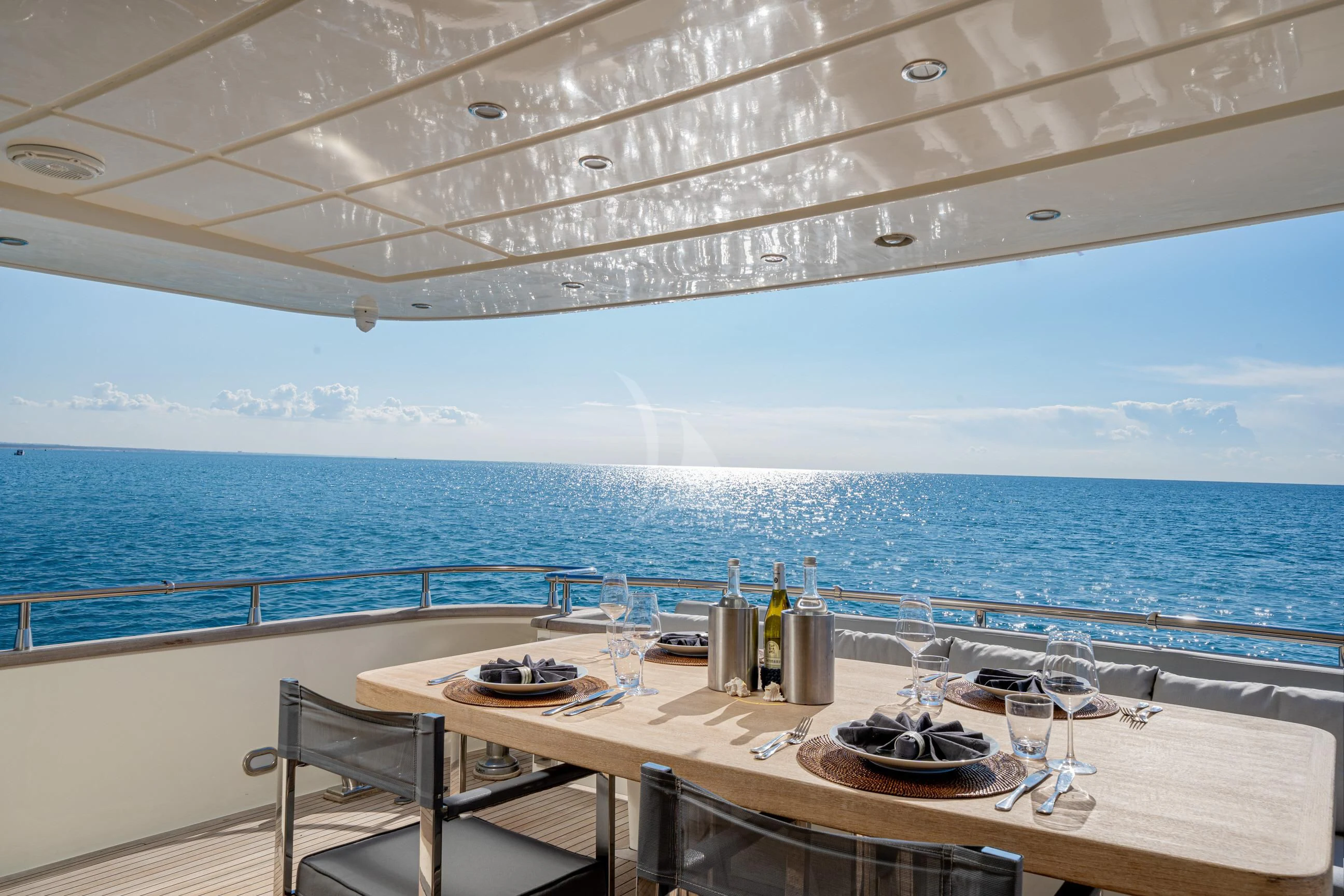 a table with a plate on it and a view of the ocean aboard MINOU Yacht for Sale