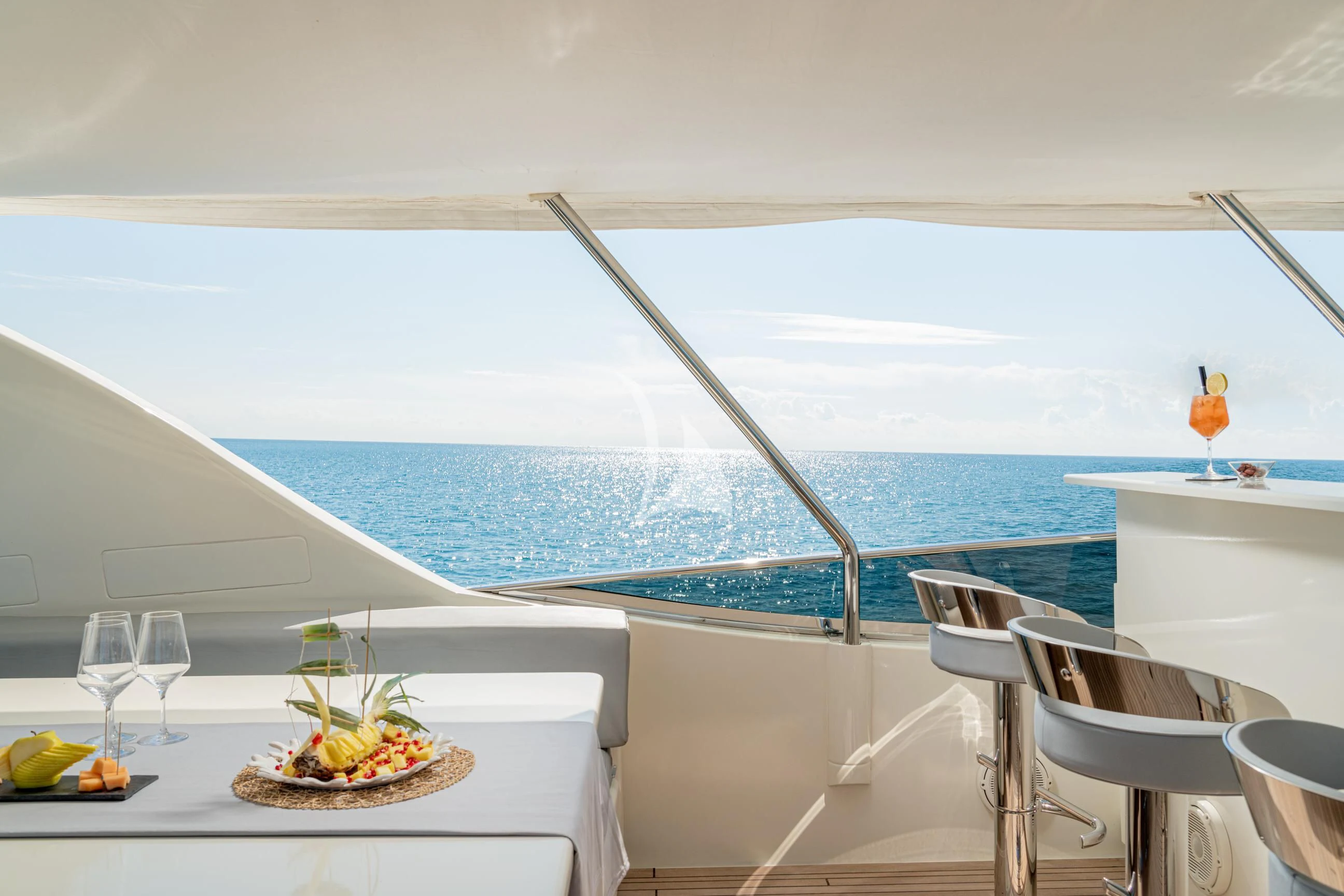 a table with a plate of food and glasses on it aboard MINOU Yacht for Sale