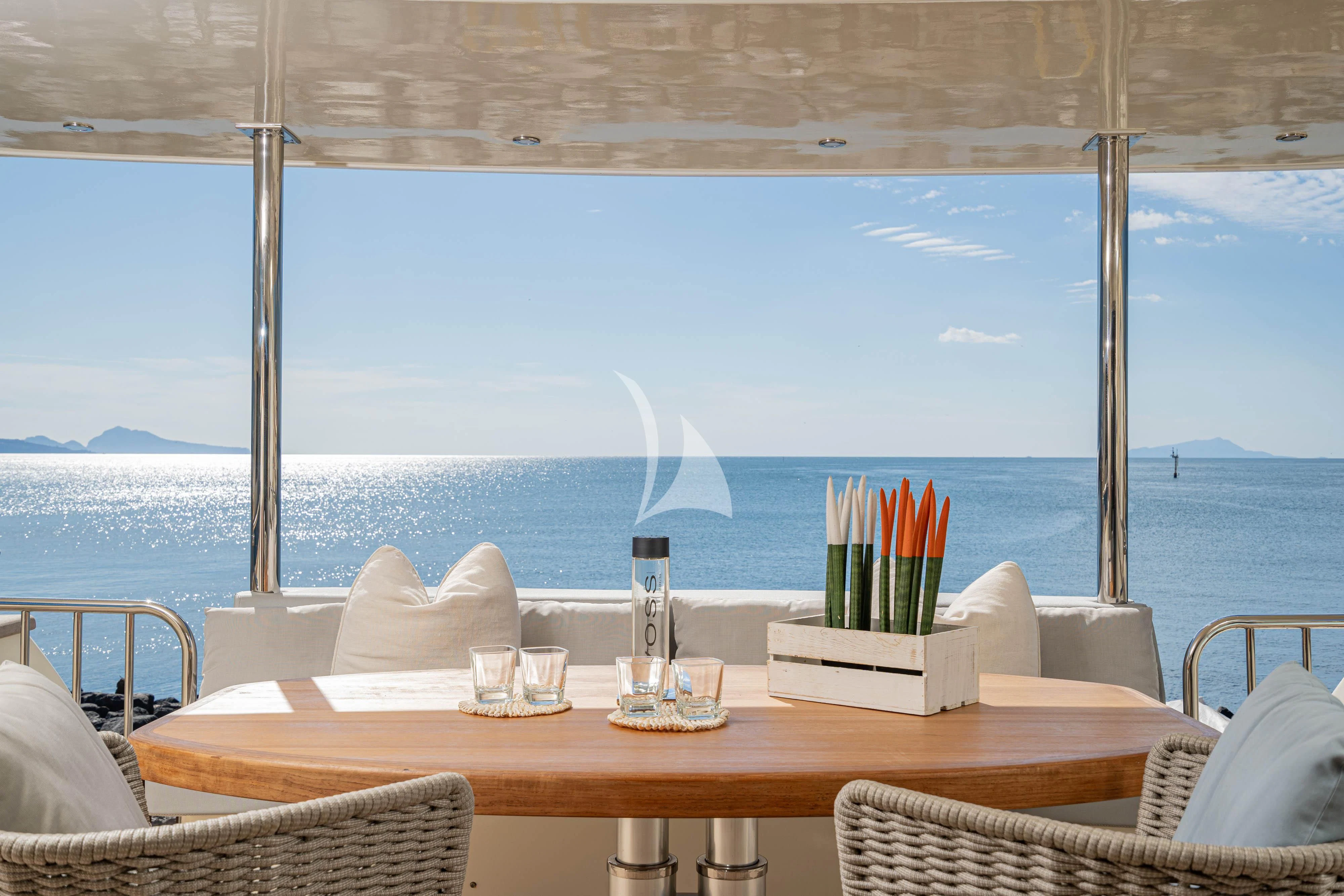 a table with a glass and a bottle of wine on it aboard MINOU Yacht for Sale