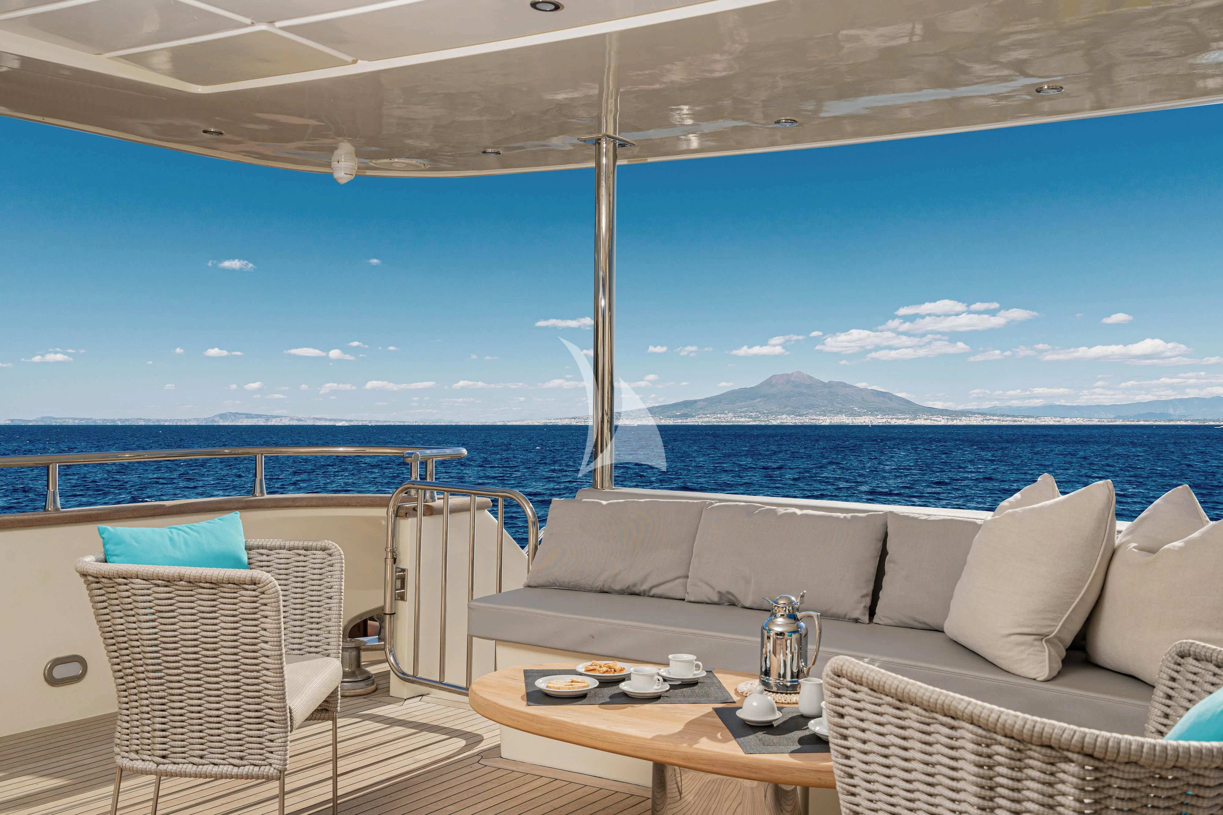 a patio with a view of the ocean and mountains aboard MINOU Yacht for Sale