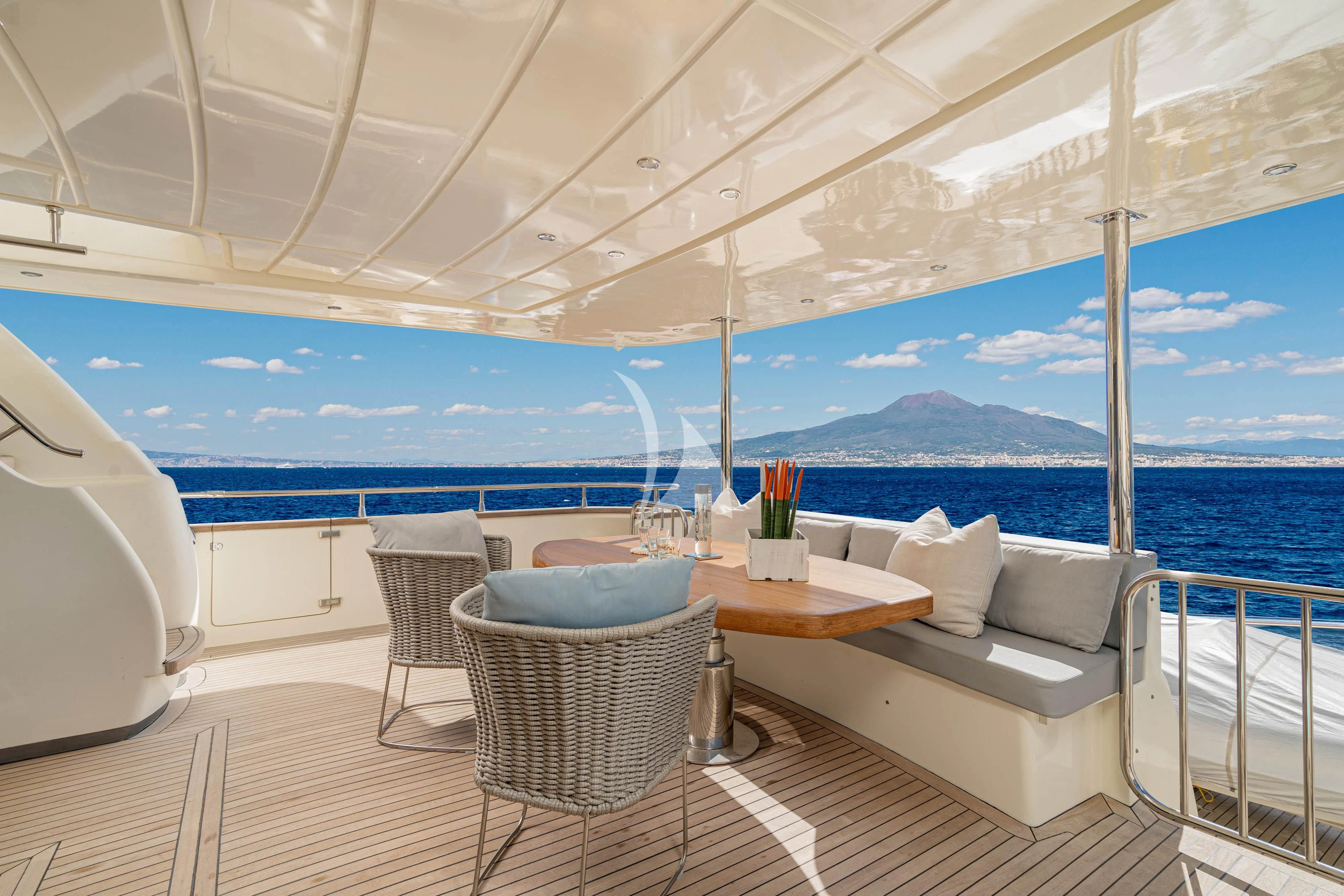 a table and chairs on a deck overlooking the ocean aboard MINOU Yacht for Sale