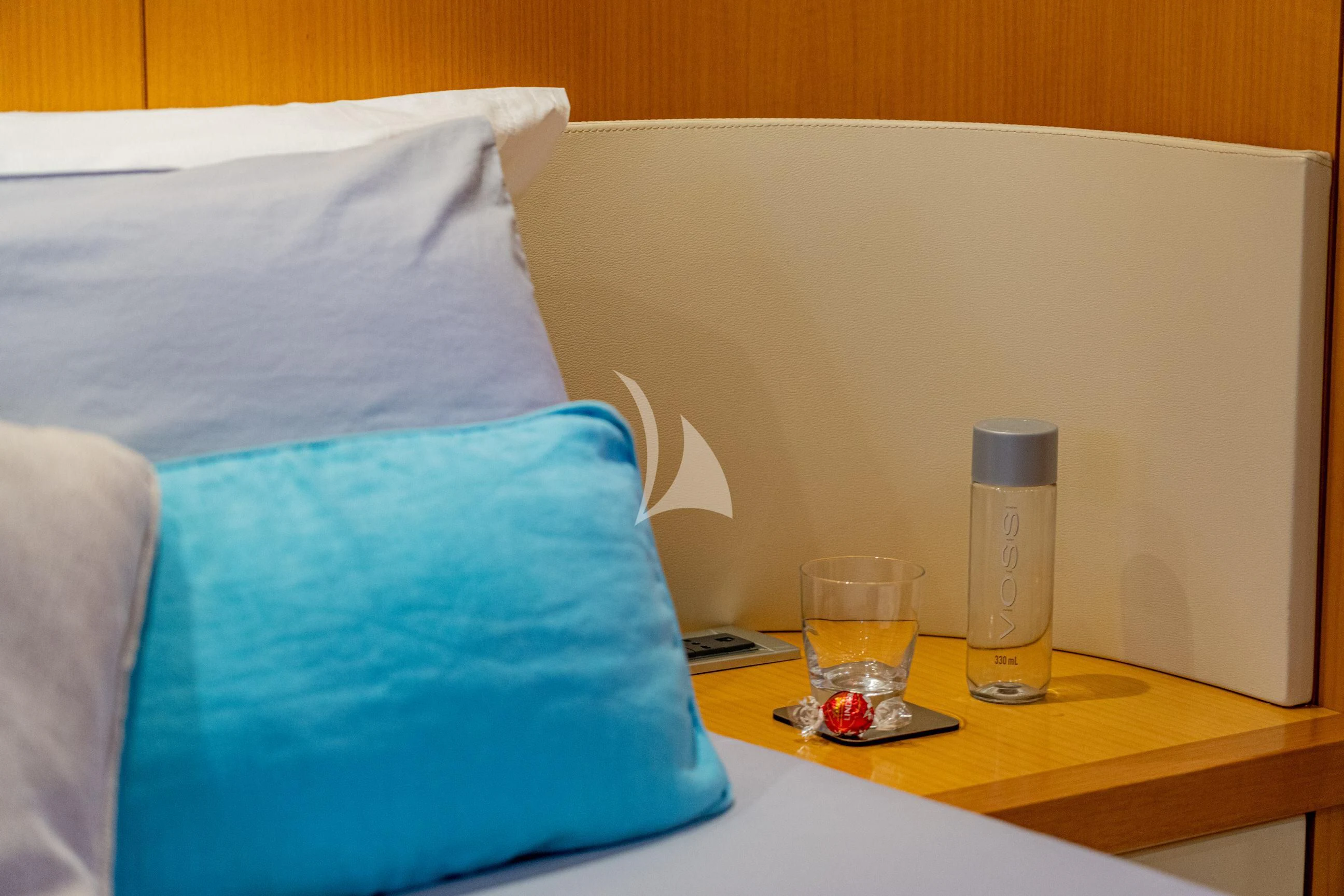 a bed with a bottle of water on it aboard MINOU Yacht for Sale