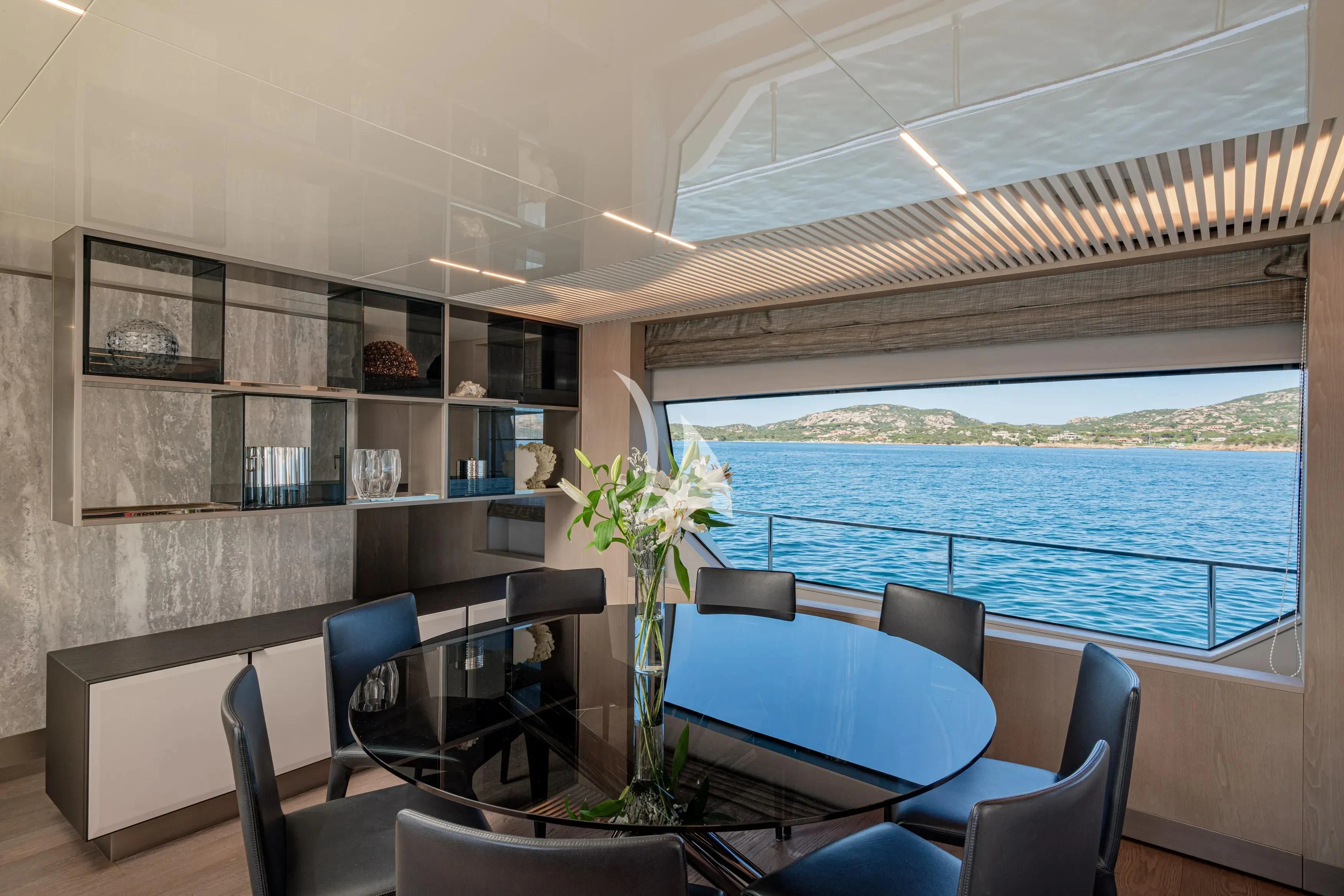 a room with a table chairs and a plant in it aboard E3 Yacht for Sale