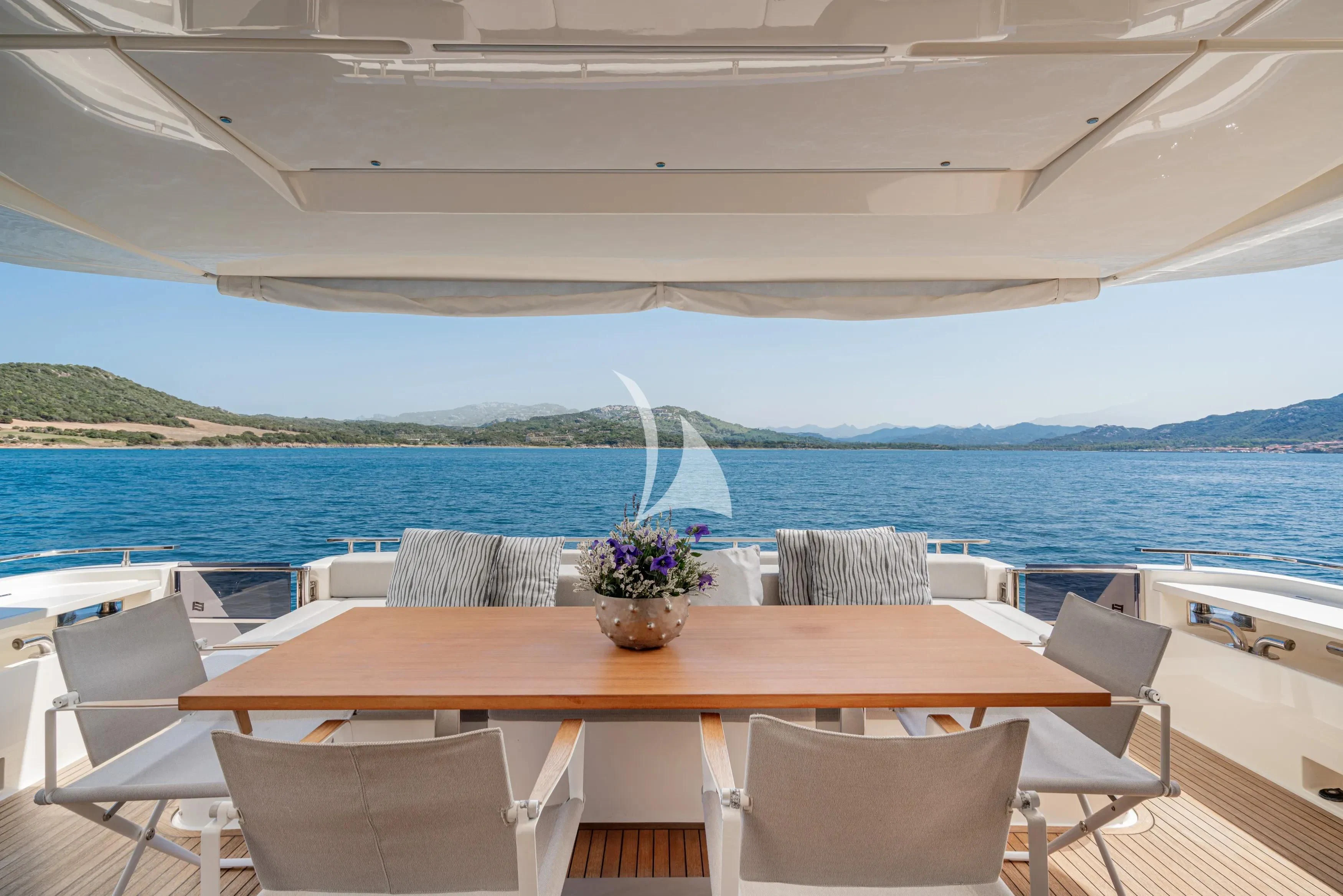 a table with chairs on it next to a body of water aboard E3 Yacht for Sale