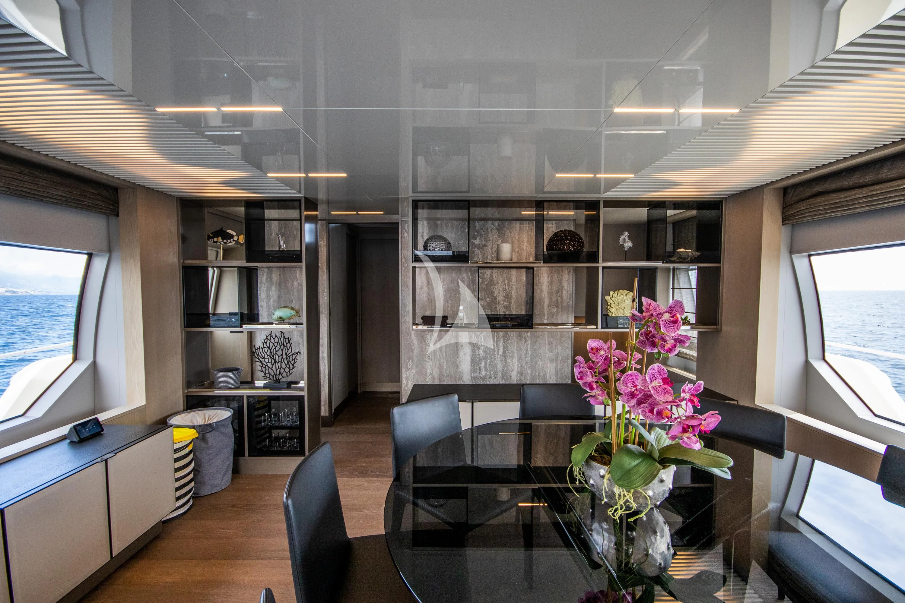 a room with a glass table and a shelf with flowers aboard E3 Yacht for Sale