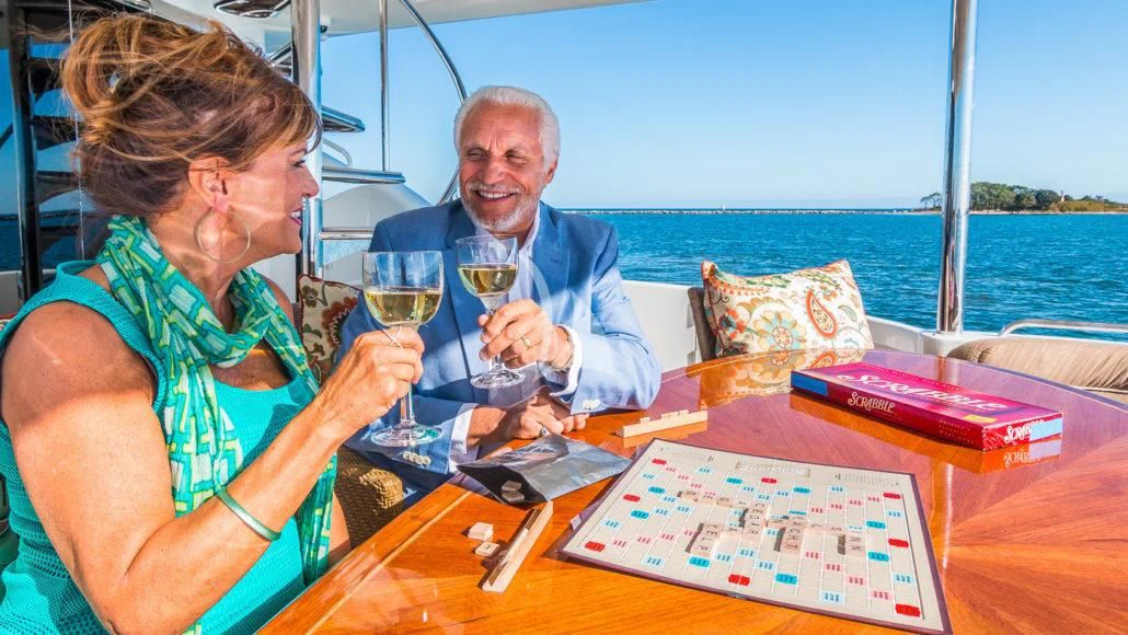 a man and a woman sitting at a table with a glass of wine aboard CEDAR ISLAND Yacht for Sale