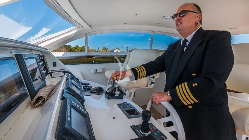 a man in a suit sitting in a car aboard CEDAR ISLAND Yacht for Sale