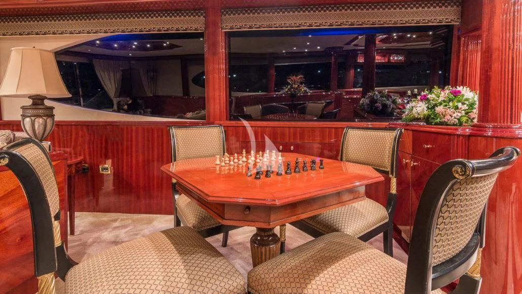 a table with a game controller and a game board in a room with chairs and a table with aboard CEDAR ISLAND Yacht for Sale