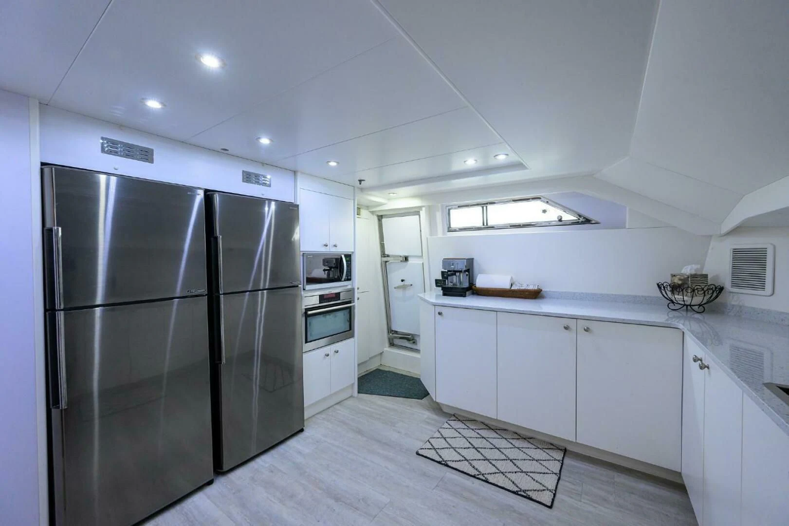 a kitchen with white cabinets aboard CIPANGO Yacht for Sale
