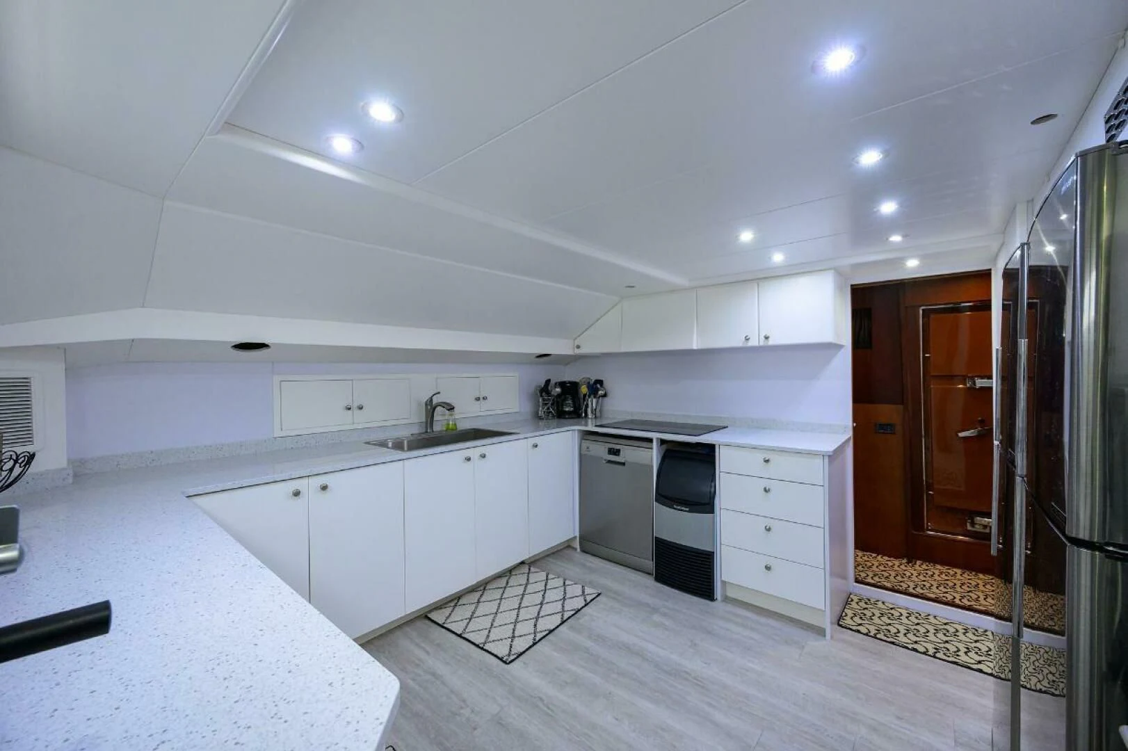 a kitchen with white cabinets aboard CIPANGO Yacht for Sale