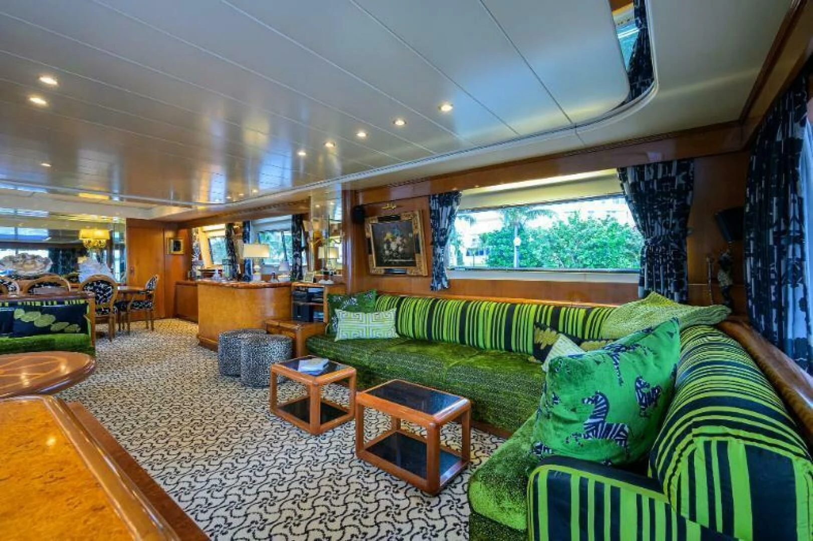 a living room with green couches aboard CIPANGO Yacht for Sale