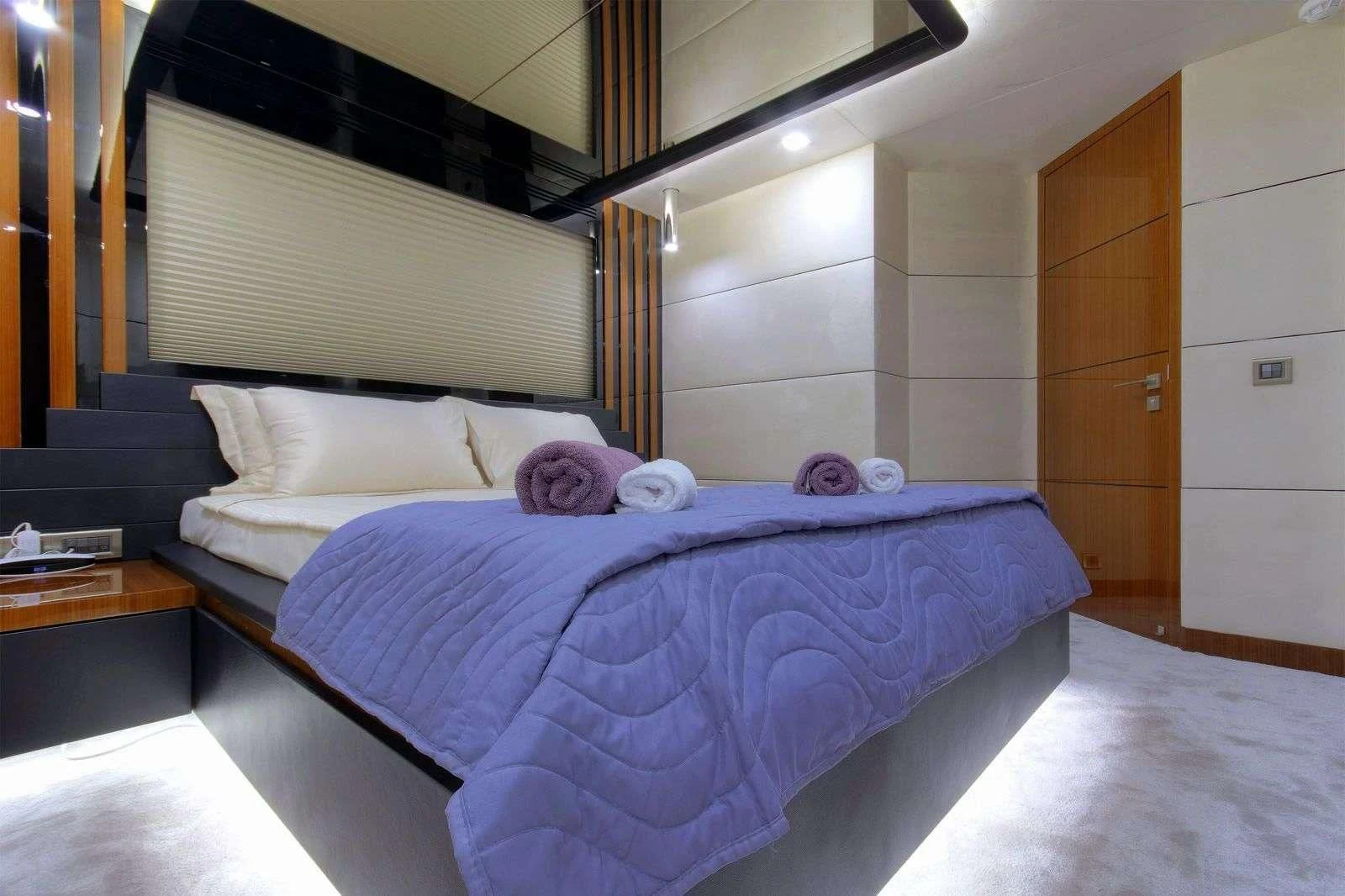 a bed with a purple comforter aboard MOSS Yacht for Sale