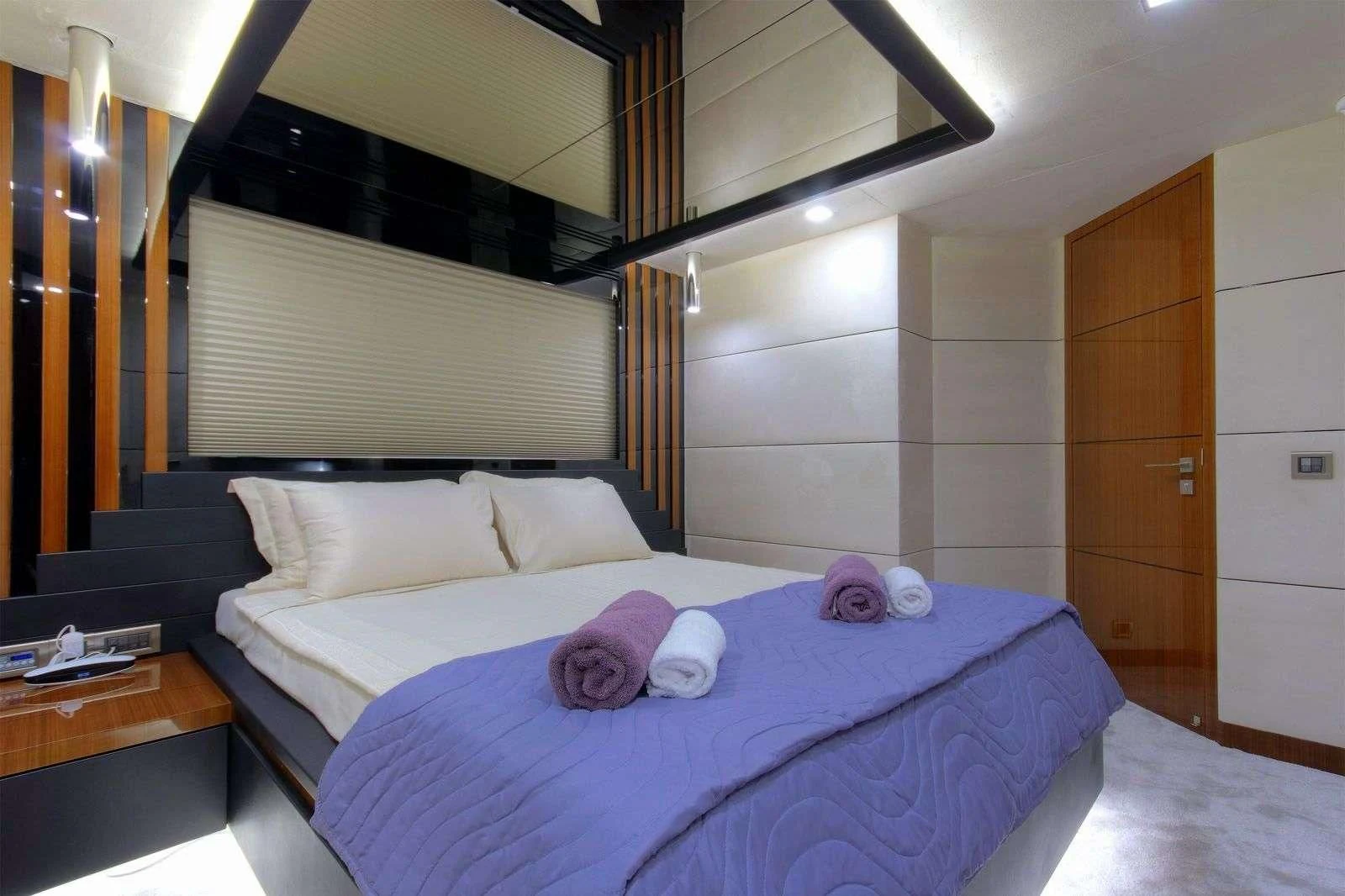 a bed with a purple blanket aboard MOSS Yacht for Sale