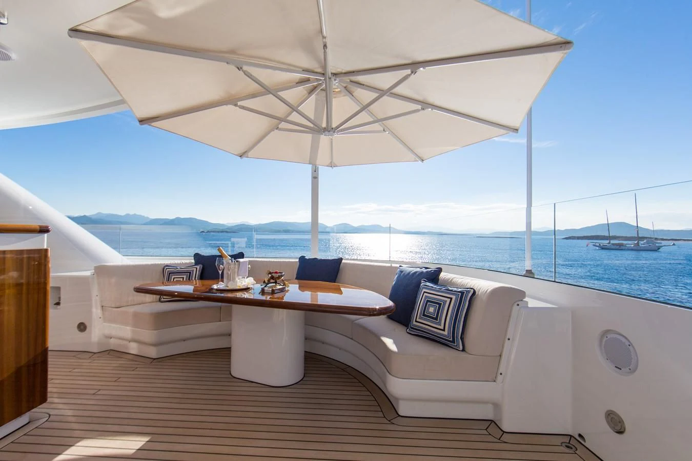 a white couch with a table and a white umbrella on it aboard HERCULES Yacht for Sale