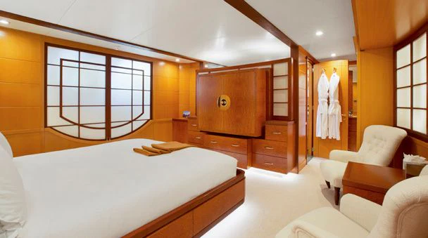 a bedroom with a bed and a chair aboard HERCULES Yacht for Sale