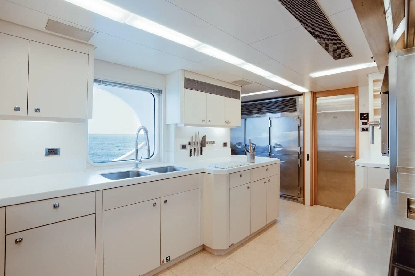 a kitchen with white cabinets aboard HERCULES Yacht for Sale
