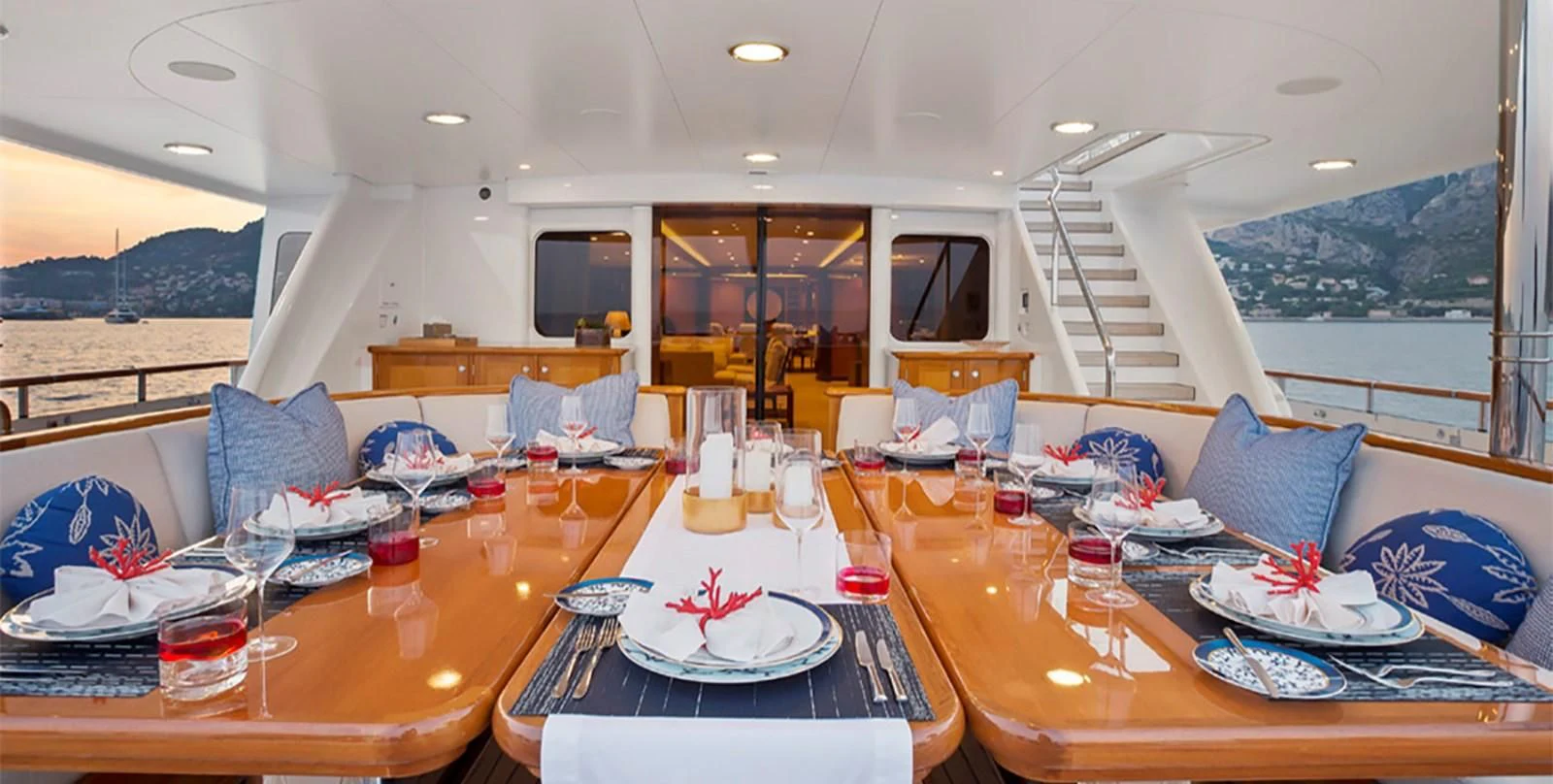 a dining room with a view of the ocean and the mountains aboard HERCULES Yacht for Sale