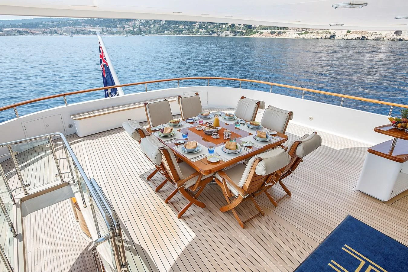 a deck with a table and chairs on it aboard HERCULES Yacht for Sale