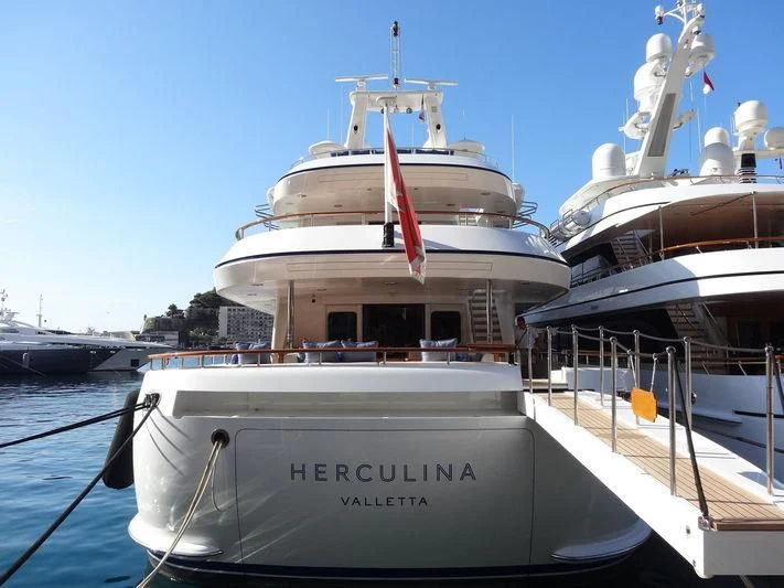 a large white boat with a red and white stripe on it aboard HERCULES Yacht for Sale