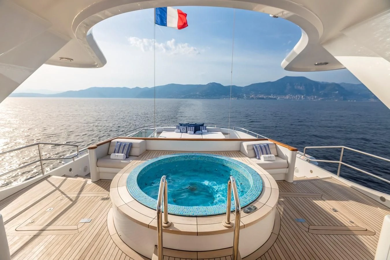 a large pool on a deck overlooking a large body of water aboard HERCULES Yacht for Sale