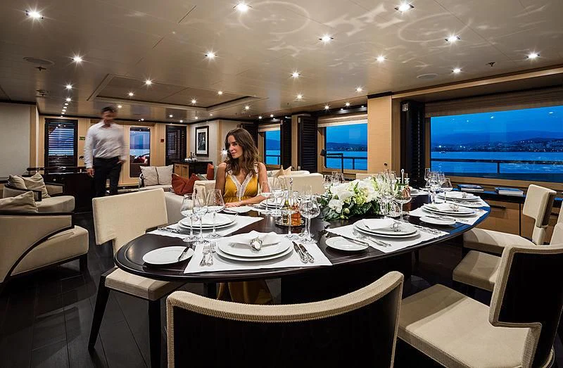 a person sitting at a table with plates and glasses on it aboard GRACE (YET) Yacht for Sale