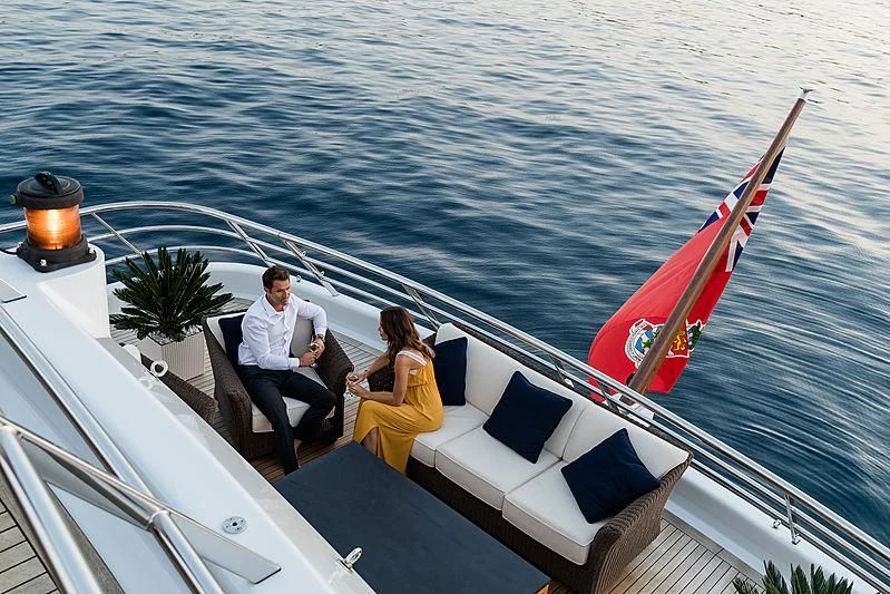 a man and woman sitting on a boat with a red sail aboard GRACE (YET) Yacht for Sale