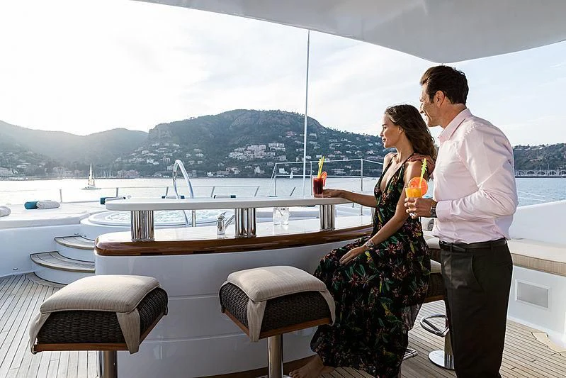 a man and woman standing on a balcony overlooking a body of water aboard GRACE (YET) Yacht for Sale