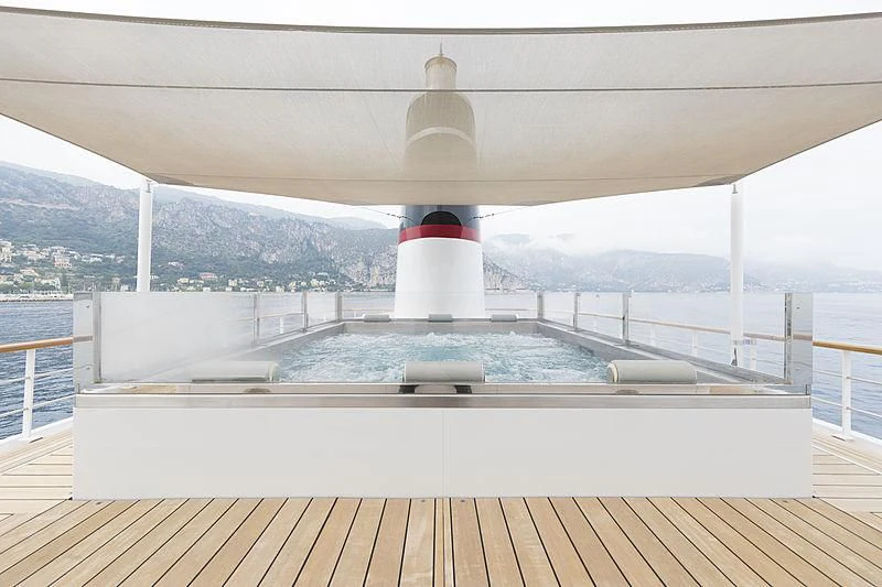 a white and red pool with a view of mountains and water aboard JESTER Yacht for Sale