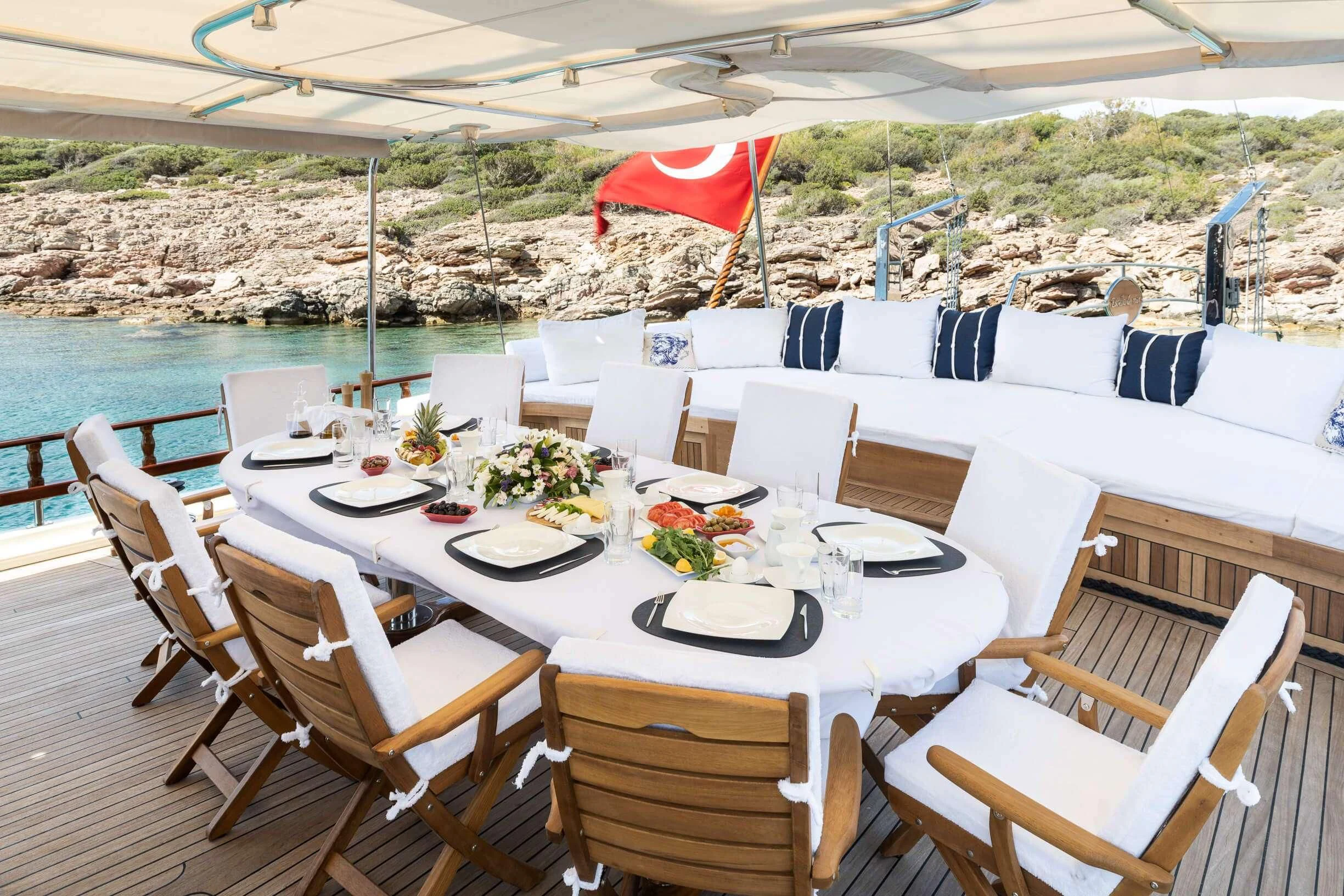 a table set for a meal on a beach aboard ESTRELLA DE MAR Yacht for Sale