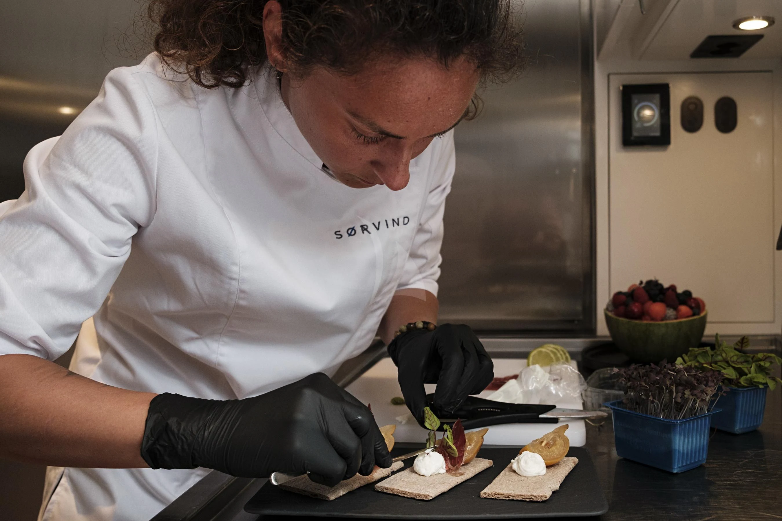 a chef preparing food in a kitchen aboard SORVIND Yacht for Charter