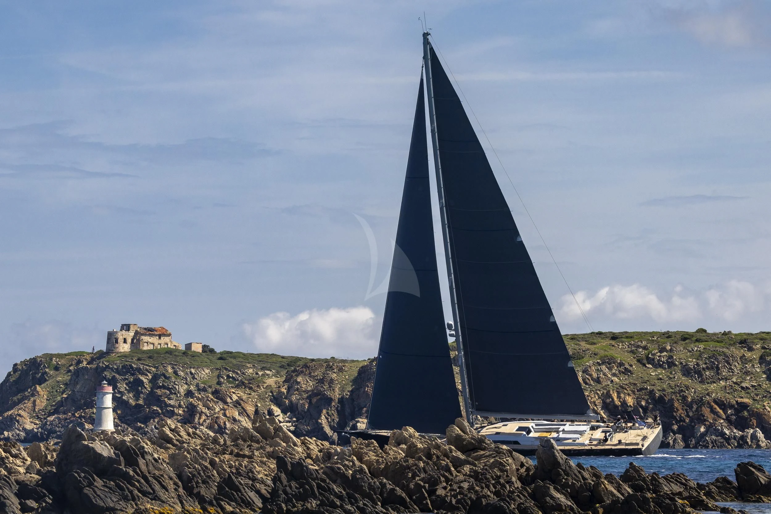 a sailboat on a rocky shore aboard SORVIND Yacht for Charter