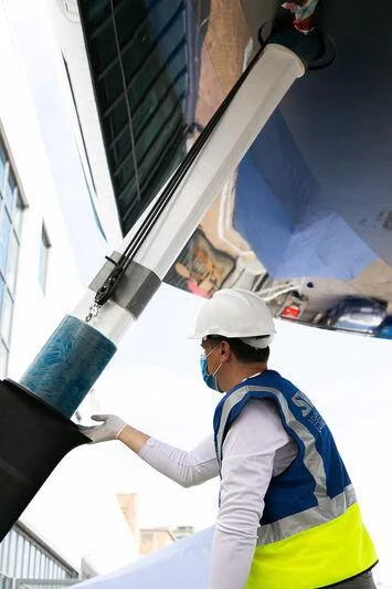 a person in a hard hat and safety goggles leaning on a building aboard SORVIND Yacht for Charter