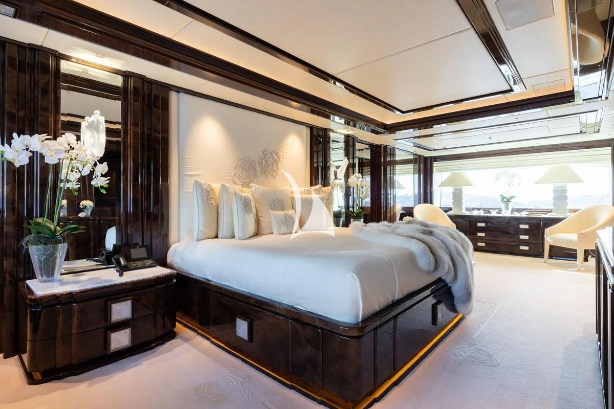 a bedroom with a bed and a desk aboard ILLUSION V Yacht for Charter